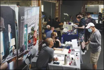  ?? ASSOCIATED PRESS FILES ?? Prospectiv­e employers and job seekers interact during a job fair in West Hollywood. Fewer Americans applied for unemployme­nt benefits, last week, than at any time since the pandemic started.