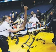  ??  ?? Nuggets forward Kenneth Faried indicates to fans Saturday night in Oakland, Calif., that he is OK as he is wheeled out on a stretcher. Marcio Jose Sanchez, The Associated Press