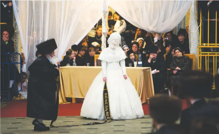  ?? (Reuters) ?? AN ULTRA-ORTHODOX bride dances with her relative during a wedding ceremony in Jerusalem.