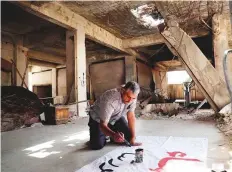  ?? AFP ?? Bahr Nahhas prepares a poster ahead of a demonstrat­ion in the rebel-held town of Maaret Al Numan, north of Idlib.