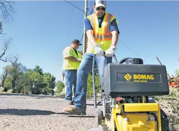  ??  ?? Santa Fe Mayor Javier Gonzales on Friday works with city workers filling potholes.