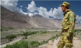  ?? ?? A Tajik soldier watches the border area across the Panj River in the Wakhan Corridor, a narrow strip of land separating Afghanista­n from its neighbours. Photograph: Pascal Mannaerts/Alamy