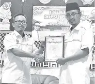  ??  ?? PENYELIA SAR Kafa dan Kurikulum SMKA dan SABK Ustaz Mohd. Azhari Mohd. Khair(kiri) menerima sijil penghargaa­n daripada Pengetua SMKA Keningau Ustaz Haidon Hadi Sapiri(kanan).