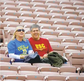  ?? MARK J. TERRILL AP ?? Steve and Susan Clark sit in the stands before a football game between USC and UCLA in Pasadena. The Pac-12 will be scrambling to survive with departure of Trojans and Bruins.