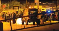  ?? (Mohamad Torokman/Reuters) ?? SOLDIERS GATHER on Monday at the scene of the shooting attack at a checkpoint south of Beit El.