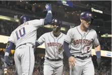  ?? Thearon W. Henderson / Getty Images ?? Marwin Gonzalez (9) celebrates with Yuli Gurriel (10) and Alex Bregman after belting a three-run home run against Giants reliever Will Smith with two outs in the ninth inning.