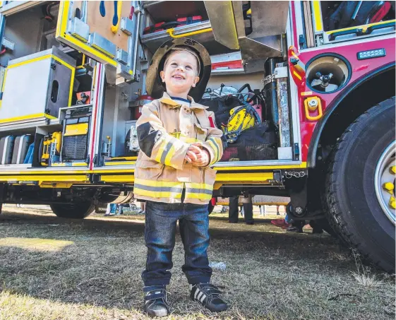  ?? Picture: JERAD WILLIAMS ?? There could not have been a better place for Ethan Andrews, 2, to be than dressed in his firies suit at the Monster Machinery Day yesterday.