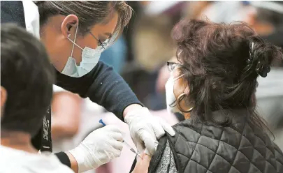  ??  ?? An elderly woman is vaccinated with the Chinese Sinovac vaccine in Mexico City in Mexico on Monday. Earlier, brigades of health care workers began to administer the vaccine to hundreds of residents aged 60 and over who went to the Las Americas cultural and sports center to get vaccinated. — Xinhua