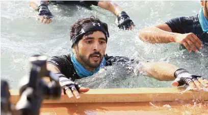  ??  ?? LEAD FROM THE FRONT ... Sheikh Hamdan tackles an obstacle during the Sandstorm obstacle marathon. Known for his fearless spirit and love for sports and adventure, Sheikh Hamdan led the first wave of runners who took on the challenge.
