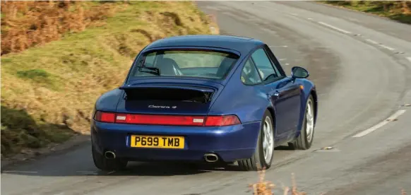  ??  ?? Fussy purists may not like the Carrera 4’s four-wheel drive drivetrain but it’s hard to argue against the 993’s remarkable roadholdin­g, whatever the road conditions. From the rear, it’s obvious how the 911 was starting to put on weight…