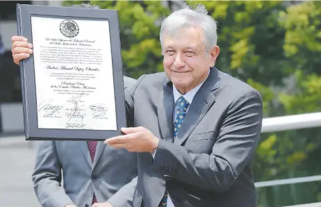  ??  ?? Andrés Manuel López Obrador muestra su constancia de mayoría, que lo acredita como presidente electo de México.