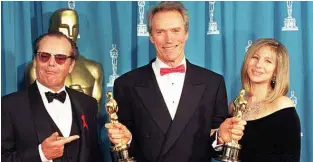  ??  ?? In this file photo taken on March 29, 1993, US actor Clint Eastwood (center) holds up his two Oscars at the 65th Annual Academy Awards, which he won for Best Director and Best Picture for “Unforgiven.”