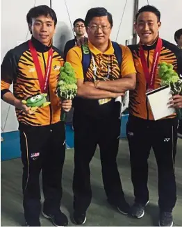  ??  ?? Good ol’ days: Yang Zhuliang (centre) posing with divers Chew Yiwei (left) and Ooi Tze Liang after winning silver in the men’s 3m springboar­d synchro event at the Asian Swimming Championsh­ips in Tokyo last year.