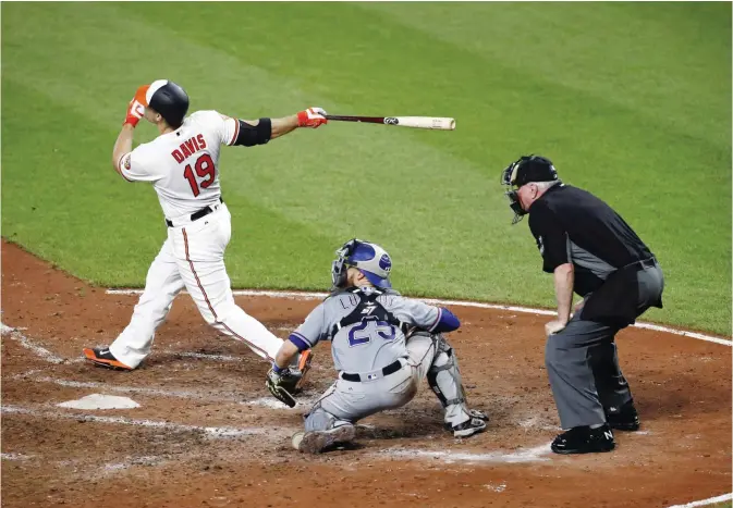  ?? —AP ?? BALTIMORE: Baltimore Orioles’ Chris Davis watches his grand slam in front of Texas Rangers catcher Jonathan Lucroy and home plate umpire Brian Gorman during the fourth inning of a baseball game in Baltimore, Tuesday.