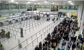  ?? AP ?? Passengers queue for flights at Gatwick Airport as the airport and airlines work to clear the backlog of flights delayed by a series of drone incidents earlier last week.