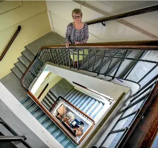  ?? PHOTO: MURRAY WILSON/FAIRFAX NZ ?? Palmerston North City Library archivist Lesley Courtney checks the staircase, currently out of bounds to the public. Investigat­ions have been requested to see if it can be preserved.