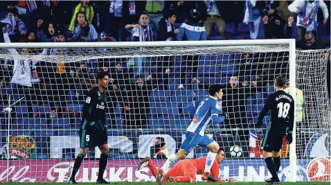  ??  ?? Espanyol Gerard Moreno (centre) scores against Real Madrid’s goalkeeper Diego Lopez during their Spanish La Liga match at RCDE stadium in Cornella Llobregat, Spain, yesterday.