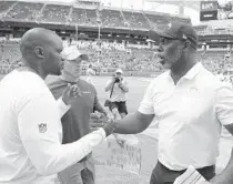  ??  ?? Chargers coach Anthony Lynn, right, greets Dolphins coach Brian Flores after a game in 2019 at Hard Rock Stadium. Lynn and Flores are among only six minority coaches in the NFL.