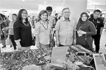  ??  ?? Sikie (second right) and Melia (second left) stop by at one of the booths during the handicraft sale carnival in Bintang Megamall.