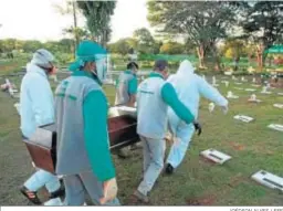  ?? JOÉDSON ALVES / EFE ?? Trabajador­es de un cementerio entierran una víctima de Covid-19 en Brasilia.