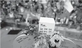  ?? REBECCA BLACKWELL/AP ?? A wooden heart is marked with messages of love at a memorial wall near the Champlain Towers South building collapse on Monday in Surfside, Florida.