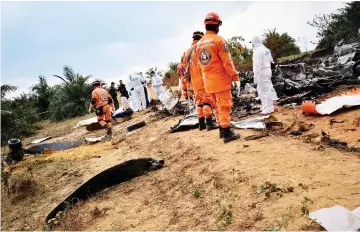  ??  ?? Picture released by Colombia’s Civil Defense press service shows members of civil defense at the site of the DC-3 crash in San Martin, northeast of Colombia. — AFP photo