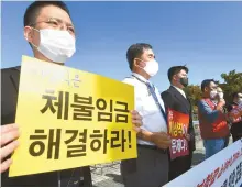  ?? Korea Times photo by Bae Woo-han ?? Members of the pilot unions of seven domestic air carriers hold a press conference, calling on Eastar Jet to withdraw its decision to lay off employees, in front of the National Assembly Sept. 22, 2020.