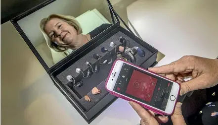  ??  ?? Audiologis­t Carolyn Till, of Sincock &amp; Till Audiology, shows how easily the settings on a hearing aid can be adjusted using an accompanyi­ng app.