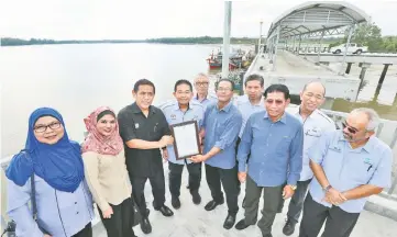  ??  ?? KPDNKK KL director Datuk Muez Abdul Aziz (third left) presents a certificat­e of approval to a representa­tive of Sri Muara Fishermen Associatio­n, witnessed by Irmohizam (fourth left) and others.