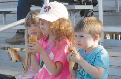  ?? Jeff Larson/appeal-democrat ?? Charlotte, Lily and Owen, of Plumas Lake, munch on some hot dogs while attending their first Gold Sox game Thursday night.