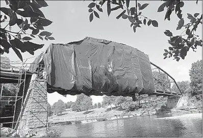  ?? NWA Democrat-Gazette/FLIP PUTTHOFF ?? War Eagle Bridge, one of the few Parker truss bridges in the state, is wrapped in sheeting during as part of monthslong renovation­s.