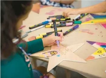  ?? ?? Children decorate wooden stars for the museum’s project connecting Miami children with those who had to flee Ukraine.