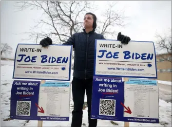  ?? NANCY LANE — BOSTON HERALD ?? Jason Palitsch holds signs calling for write in votes for Joe Biden at a polling place in Manchester, New Hampshire during the presidenti­al primary on Tuesday.