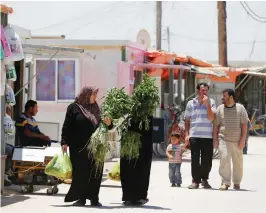  ?? (Muhammad Hamed/Reuters) ?? SYRIAN REFUGEES shop in preparatio­n for Ramadan at the main market at the Zaatari refugee camp in Mafraq, Jordan, near the border with Syria, last week.