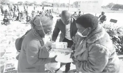  ??  ?? Minister of State for Bulawayo Provincial Affairs and Devolution Cde Judith Ncube presents groceries to the vulnerable in Emakhanden­i, Bulawayo yesterday. In the picture she hands over groceries to Gogo Dorothy Chanaka while Well of Hope Zimbabwe representa­tive Mr Nqobizitha Ndlovu assists. Picture by Eliah Saushoma