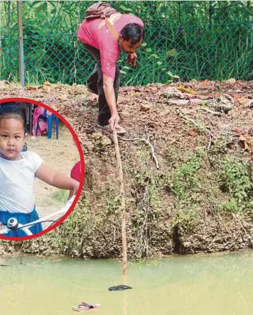  ??  ?? PENDUDUK kampung, Roby Muhammad menunjukka­n selipar milik Nur Damia Nadhirah (gambar kecil) yang lemas selepas tergelinci­r ke dalam kolam tadahan.