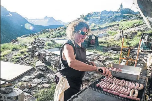  ?? XAVIER CERVERA ?? Patrick Cortade preparando unas butifarras para cerca de sesenta comensales, en la barbacoa del refugio de Pinet