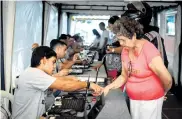  ??  ?? Varias personas realizan el registro biométrico en la IED Manuel Zapata Olivella en el barrio Me Quejo.