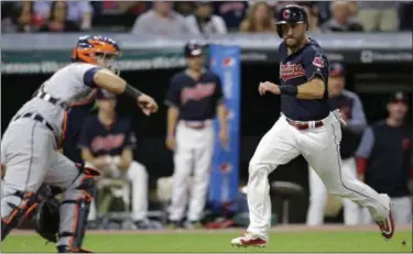  ?? TONY DEJAK — THE ASSOCIATED PRESS ?? The Indians’ Lonnie Chisenhall scores as Tigers catcher Alex Avila waits for the ball during the eighth inning.