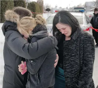  ?? RYAN REMIORZ/ THE CANADIAN PRESS ?? Friends of the three victims found dead in a Trois-Rivières home on Tuesday try to comfort each other.
