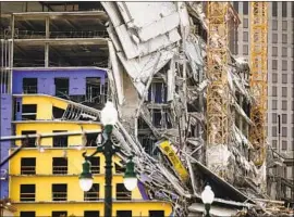  ?? Emily Kask AFP/Getty Images ?? THE UPPER FLOORS of a Hard Rock Hotel project collapsed Saturday in New Orleans. A crane looming over the building is dangerousl­y unstable, officials say.