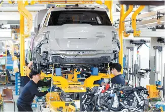 ?? Courtesy of KG Mobility ?? Workers assemble Torres EVX SUVs at KG Mobility’s production line in Pyeongtaek, Gyeonggi Province, Tuesday.