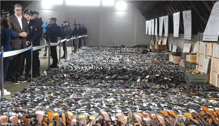  ?? ?? In this photo provided by the Serbian Presidenti­al Press Service, Serbian President Aleksandar Vucic, left, inspects weapons collected as part of an amnesty near the city of Smederevo, Serbia. On Sunday, Serbian authoritie­s displayed some of the around 13,500 weapons they say have been collected since last week's mass shootings, including automatic weapons, hand bombs and anti-tank grenades. Photo: Serbian Presidenti­al Press Service via AP