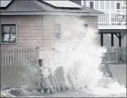  ?? PETER PEREIRA — THE STANDARD-TIMES VIA AP ?? A wave crashes into the retaining wall of a home in Fairhaven, Mass., on Tuesday.