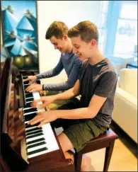  ?? (AP/Andrea Fage) ?? Brothers Rafael Fage (background), 16, and Noah Fage, 14, play the piano on Nov. 20 at their home in Harrison, N.Y.