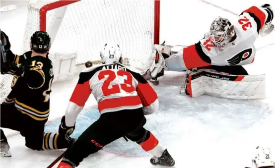  ?? BARRY CHIN/GLOBE STAFF ?? Charlie Coyle (left) swept in a one-timer past Flyers goaltender Felix Sandstrom to tie the score at 2 in the second period.