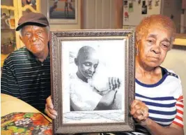  ?? CARLINE JEAN/SOUTH FLORIDA SUN SENTINEL ?? Mickey and Joan Hinton with a portrait of a daughter, Gale, who died of cancer at age 52. The Hintons say toxic waste from a municipal incinerato­r caused chronic health problems.