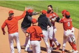  ?? AARON DOSTER/ASSOCIATED PRESS ?? Cincinnati Reds’ Jesse Winker, back right, celebrates with teammates after hitting an RBI walk-off single during the 10th inning against the Chicago White Sox.