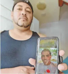  ?? STAFF PHOTO BY PATRICK WHITTEMORE ?? UNCLE’S GRIEF: Juan Martinez, the uncle of shooting victim Jerry Gomes, displays a photo of his nephew yesterday in front of his home.