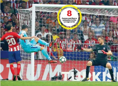  ?? Reuters ?? Games and Barca unbeaten in the La Liga so far Barcelona’s striker from Uruguay, Luis Suarez scores the equaliser against Atletico Madrid during the Spanish La Liga match. —